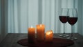 The concept of dating, joint recreation. Romantic evening. Candles are burning on the table next to glasses of red wine Royalty Free Stock Photo