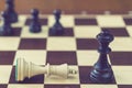 Concept of defeat, fallen king, camera focus on white king chess piece, background blurred. chess board with chess wooden pieces. Royalty Free Stock Photo