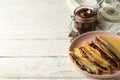 Concept of delicious breakfast with crepes with chocolate paste on white wooden background