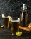 Concept of delicious drink with glasses and bottle of ginger beer on wooden table