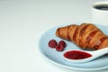 Concept of delicious food with croissant with raspberry jam on white background