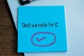 Concept of Deliverables write on sticky notes isolated on Wooden Table Royalty Free Stock Photo