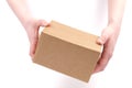 Concept of delivery, package, storage, transfer of the package. Women`s hands hold a cardboard box on a white background