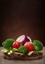 Concept design image for a cookbook or magazine cover vegetables on a wooden platter on dark background