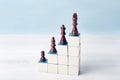 There are chess pieces on the stairs made of cubes. The pawn is on the first step, and the king is on the top step Royalty Free Stock Photo