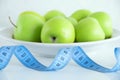 The concept of diet. Green apples on a white background and meter. Royalty Free Stock Photo