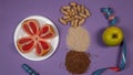 Concept diet - healthy food with apple, grapefruit, peanut, sesame, flax seeds and measuring tape on purple background