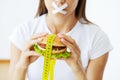 The concept of diet woman with sealed mouth keeps greasy burger Royalty Free Stock Photo