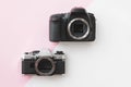 Concept - Digital vs. Analog SLR Camera on Pink Background Royalty Free Stock Photo