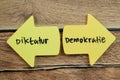 Concept of Diktatur or Demokratie in Language Germany write on sticky notes isolated on Wooden Table