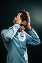 The concept of domestic violence. A teenage boy holds his hands over his head, experiencing stress. Vertical Royalty Free Stock Photo