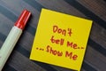 Concept of Don\'t Tell Me, Show me write on sticky notes isolated on Wooden Table