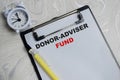 Concept of donor-adviser fund write on clipboard isolated on Wooden Table Royalty Free Stock Photo