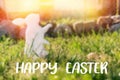 The concept of Easter holidays. Decorative handmade craft in the form of a rabbit, located next to the painted egg. Green grass in Royalty Free Stock Photo