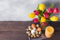 Concept Easter, tulips in a vase and a basket of eggs, a candle on a gray background. Copy space for product or text Royalty Free Stock Photo