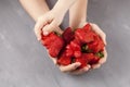 Concept - Eating ugly fruits and vegetables. Children`s hand takes a ripe funny strawberries of unusual shape from female hands.