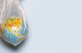 The concept of ecology. Globe in plastic wrap on a blue background. plastic waste environmental pollution concept Royalty Free Stock Photo