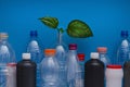 Concept: ecology, life, environmental conservation. Plastic bottles and green sprout on a blue background. Garbage