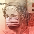 Coronavirus - Fifty brazilian reais banknote face wearing a mask