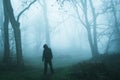A concept edit of an eerie spooky figure without a face, standing in a foggy winters forest Royalty Free Stock Photo