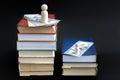 concept of education and income. Wooden figures dollars and books on a black background