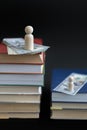 concept of education and income. Wooden figures dollars and books on a black background. vertical photo