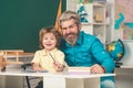 Concept of education and reading. Kid and teacher is learning in class on background of blackboard. School kids. Cute Royalty Free Stock Photo