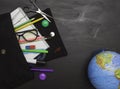 Concept of education, school children and students. Black backpack with stationery and a globe, black background, top view. Free s