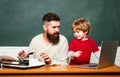 Concept of education and teaching. Teacher helping pupils studying on desks in classroom. Copy space. Elementary school Royalty Free Stock Photo