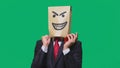 Concept of emotion, gestures. a man with a package on his head, with a painted smiley angry, sly, gloating Royalty Free Stock Photo
