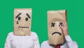 Concept of emotions, gestures. a couple of people with bags on their heads, with a painted emoticon, sad, crying, tired