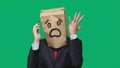 Concept of emotions, gestures. a man with paper bags on his head, with a painted emoticon, fear. talking on a cell phone Royalty Free Stock Photo