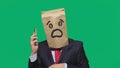 Concept of emotions, gestures. a man with paper bags on his head, with a painted emoticon, fear. talking on a cell phone Royalty Free Stock Photo