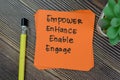 Concept of Empower, Enhance, Enable, Engage Personal Development write on sticky notes isolated on Wooden Table