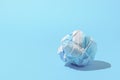 The concept of ending a pandemic. Crumpled medical mask on blue background