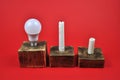 The concept of energy saving. A diode lamp and candles on a red background Royalty Free Stock Photo