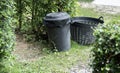 Concept of environment preservation, black plastic recycle bins placed in the garden for cleanness