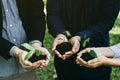 Concept of the Environment World Earth Day. Business hands holding green plants in soil together are the symbol of green business Royalty Free Stock Photo