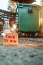 The concept of environmental pollution and waste sorting. Glass bottle with cartoon hands holding a cardboard box with the Royalty Free Stock Photo