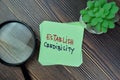 Concept of establish Credibility write on sticky notes isolated on Wooden Table