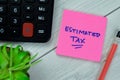 Concept of Estimated Tax write on sticky notes isolated on Wooden Table Royalty Free Stock Photo