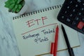 Concept of ETF - Exchange Traded Funds write on a book isolated on Wooden Table Royalty Free Stock Photo