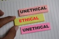 Concept of ethical or unethical write on sticky notes isolated on Wooden Table Royalty Free Stock Photo