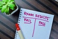 Concept of Exam Results with choice fail or pass write on book isolated on Wooden Table