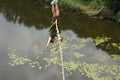 Concept of Extreme Sports and Fun. One  man is a  thrill-seeker and a  rope jumper from the bridge. He is very happy to make a Royalty Free Stock Photo