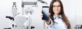 Concept of eye examination, smiling woman with spectacles showing mobile phone in optometrist office, contact us, appointment and Royalty Free Stock Photo