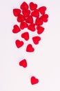 Concept of falling hearts made of heart shaped red jelly sweets on isolated white background. Top view. Royalty Free Stock Photo