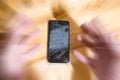 Concept of falling smart phone with broken screen. Top view on wooden desk background. Cracked, shattered lcd touch screen on Royalty Free Stock Photo