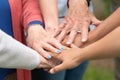 Concept of family, aging society or teamwork, hands showing unity with putting hands together, senior wrinkled hands of