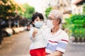 Concept of family coexistence and new ways of life. Family with grandfather and granddaughter wearing medical face mask.